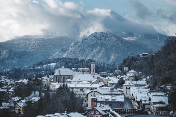 Winterlandschaft mit schneebedeckten Bergen und einem kleinen Dorf.